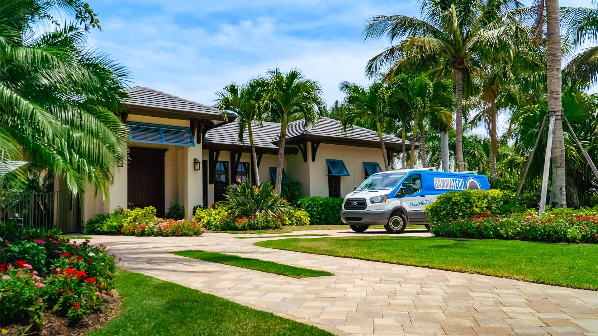 Gamma Tech service van at a palm-lined property in Southwest Florida
