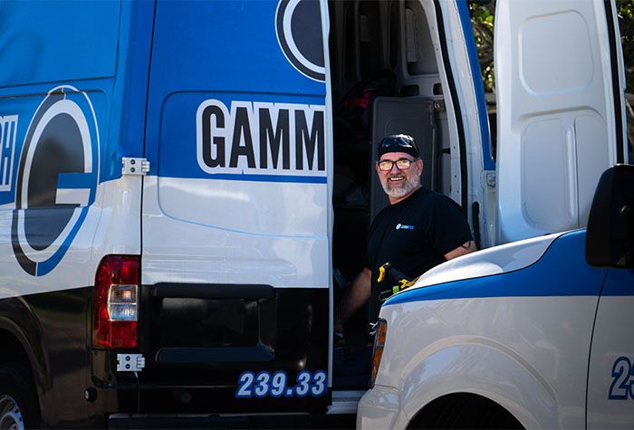 A Gamma Tech technician at a company van