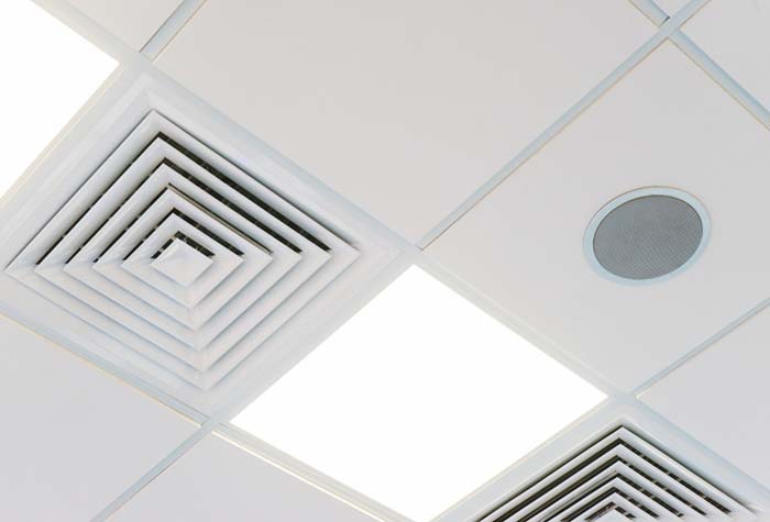 A speaker installed flush in an office ceiling