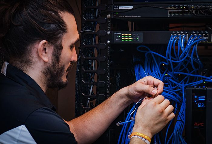 A Gamma Tech technician terminating network cabling in a rack