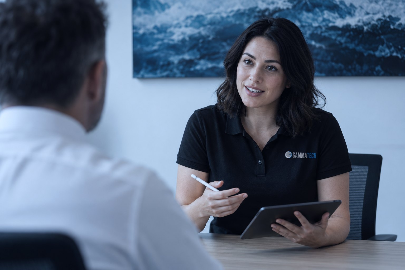 A Gamma Tech consultant in a logo polo meeting with a business client