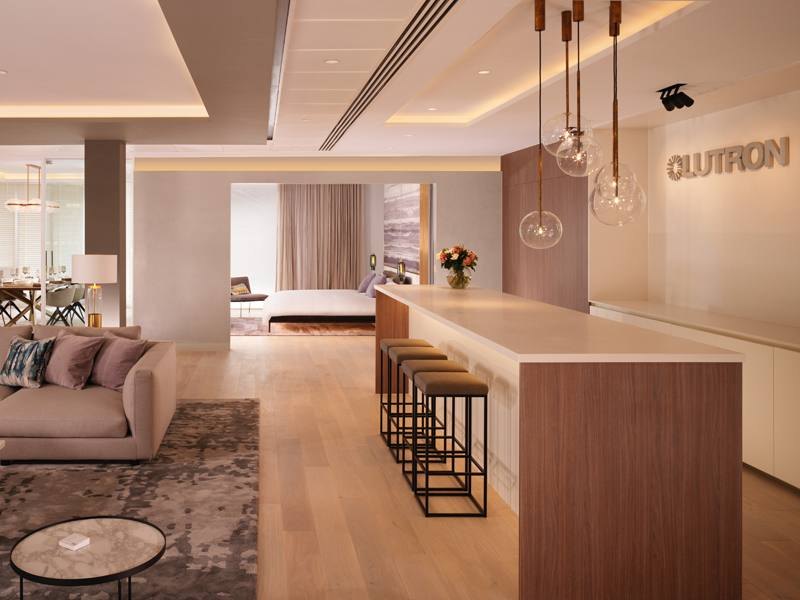 A living room and kitchen with cove, pendant and accent lighting