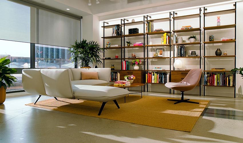 A living room with lit shelving and soft ambient light