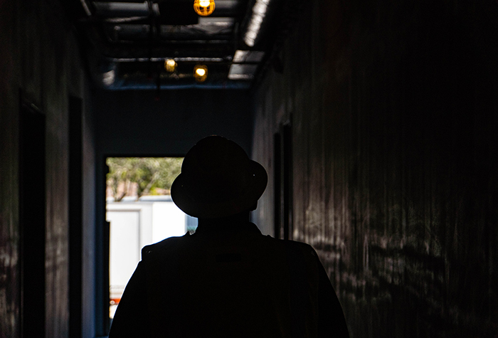 Silhouette of a Gamma Tech Services technician walking through a dark corridor