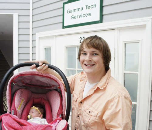 Bradd holding his baby at the first Gamma Tech office