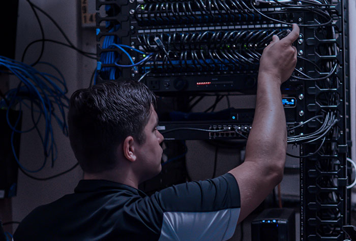 Gamma Tech IT technician working on network rack